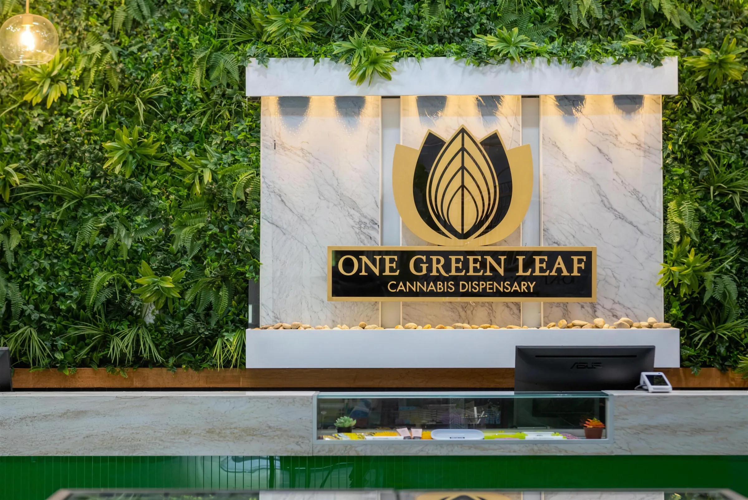The gold lotus sign on the marble feature wall and the living plant wall inside One Green Leaf Dispensary, 95 N Lakeview Dr, Gibbsboro NJ